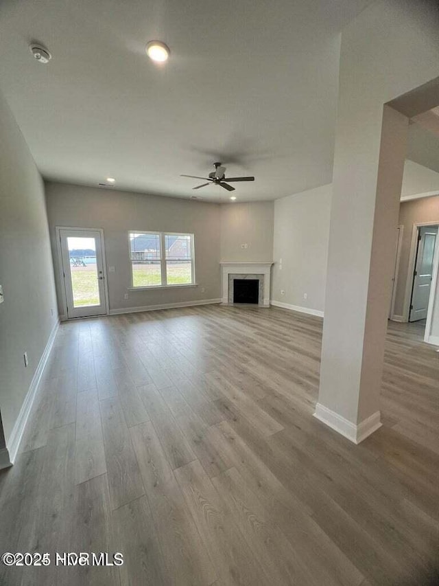 unfurnished living room with wood-type flooring and ceiling fan