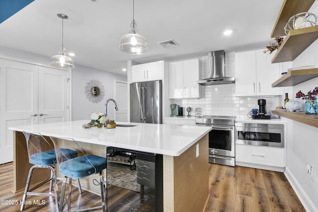 kitchen featuring dark wood-style flooring, visible vents, appliances with stainless steel finishes, wall chimney range hood, and open shelves