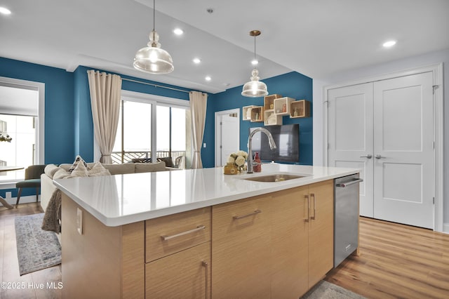 kitchen with light wood-style floors, open floor plan, light countertops, and a sink