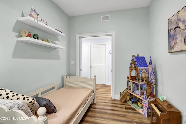 bedroom with visible vents and wood finished floors