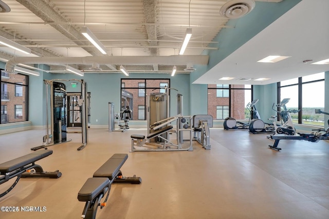 gym featuring a high ceiling and baseboards