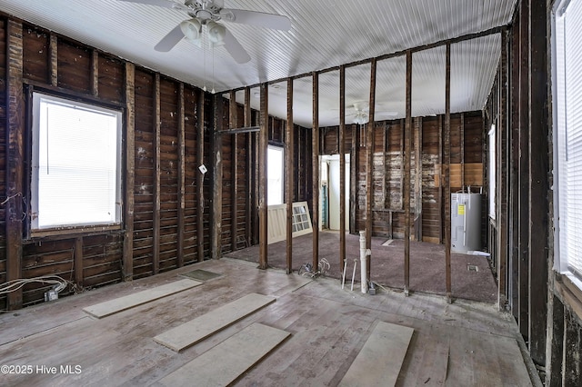 miscellaneous room with electric water heater and a healthy amount of sunlight