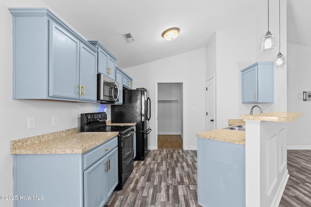 kitchen featuring blue cabinets, vaulted ceiling, dark hardwood / wood-style floors, pendant lighting, and black appliances