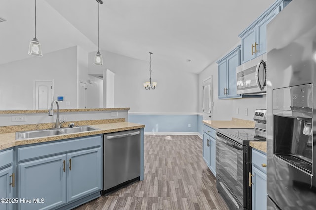 kitchen featuring blue cabinets, sink, hanging light fixtures, and appliances with stainless steel finishes