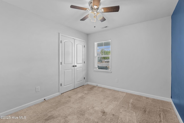 carpeted empty room featuring ceiling fan