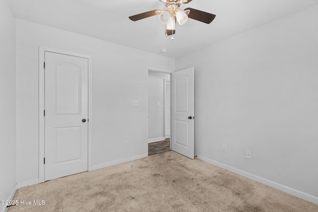 unfurnished bedroom featuring light carpet and ceiling fan