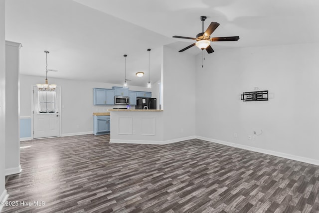 unfurnished living room with dark wood-type flooring, ceiling fan with notable chandelier, and vaulted ceiling