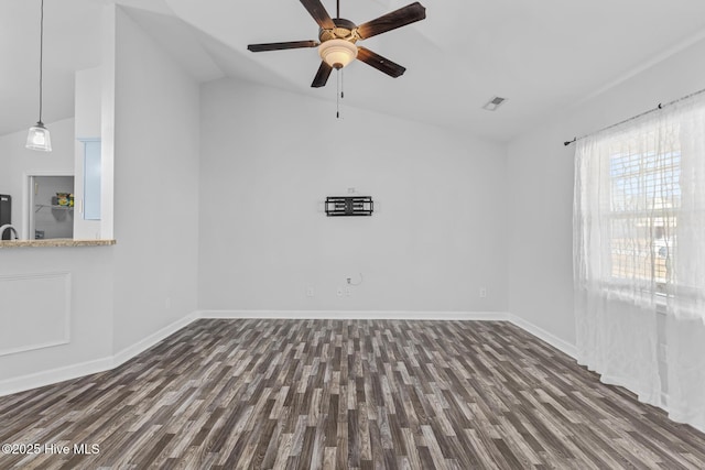 empty room featuring lofted ceiling, dark wood-type flooring, and ceiling fan