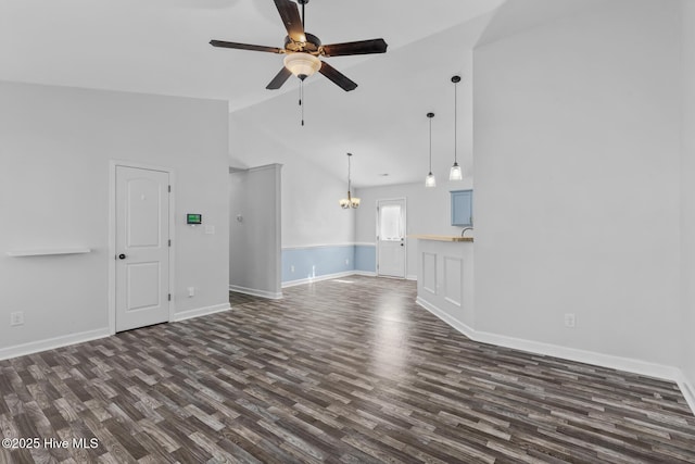 unfurnished living room featuring high vaulted ceiling, dark hardwood / wood-style flooring, and ceiling fan with notable chandelier