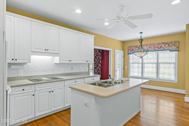1824 Starfix Ter, Wilmington, NC 28405 - kitchen featuring black electric stovetop, a ceiling fan, light countertops, pendant lighting, and light wood-style floors