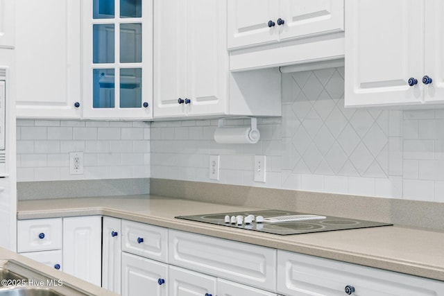 1824 Starfix Ter, Wilmington, NC 28405 - kitchen featuring white cabinetry, light countertops, glass insert cabinets, decorative backsplash, and black electric cooktop