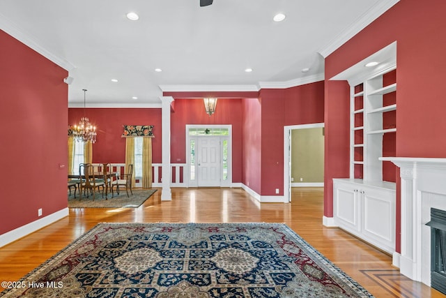 1824 Starfix Ter, Wilmington, NC 28405 - foyer entrance featuring a chandelier, wood finished floors, recessed lighting, a fireplace with flush hearth, and crown molding