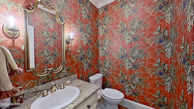 bathroom featuring vanity, crown molding, and toilet