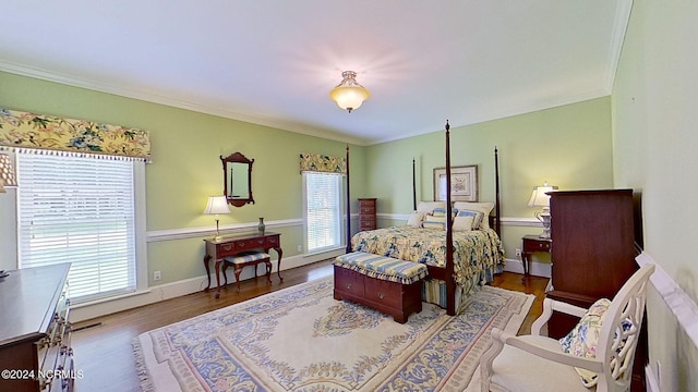 bedroom with multiple windows, hardwood / wood-style flooring, and ornamental molding