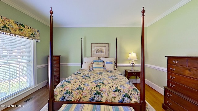 bedroom with wood-type flooring and ornamental molding