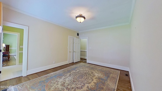 empty room with crown molding and hardwood / wood-style flooring