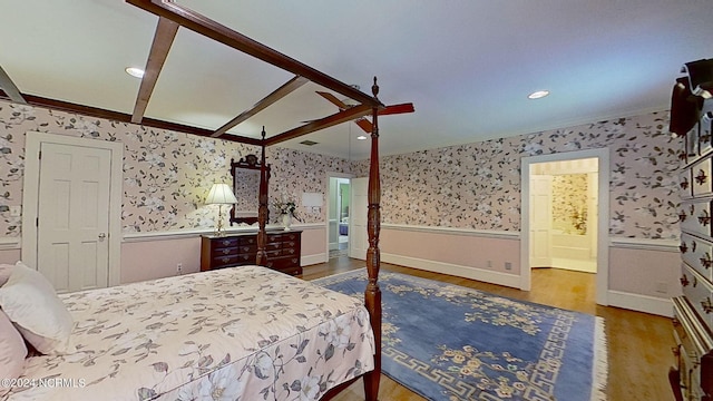 bedroom featuring crown molding, hardwood / wood-style flooring, ensuite bath, and ceiling fan