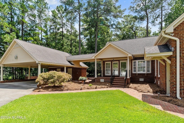 view of front facade with a carport, a porch, and a front yard