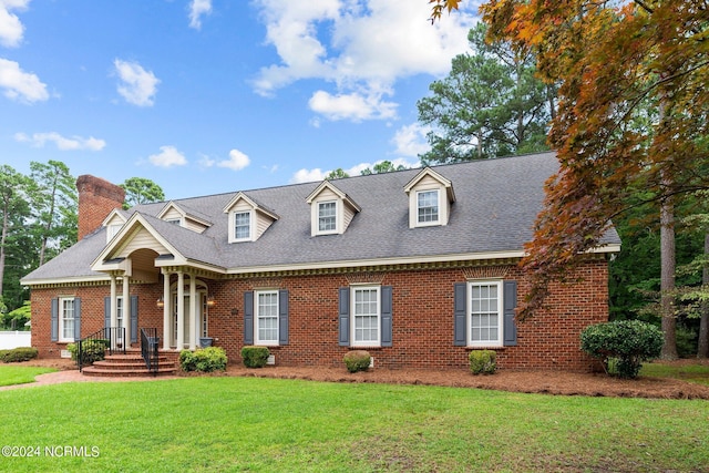 cape cod home with a front yard