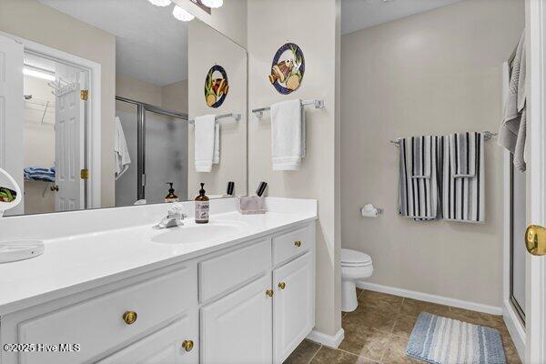 bathroom featuring vanity, toilet, and walk in shower