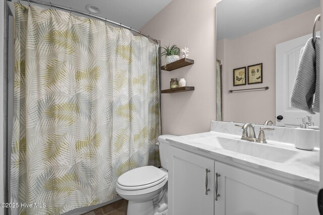 bathroom featuring tile patterned floors, vanity, and toilet