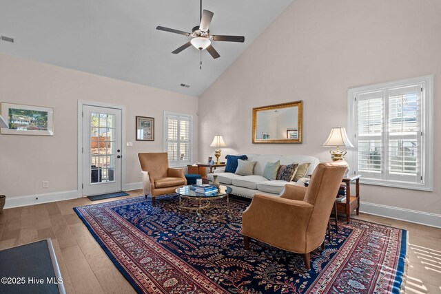 living room with ceiling fan, wood-type flooring, and high vaulted ceiling