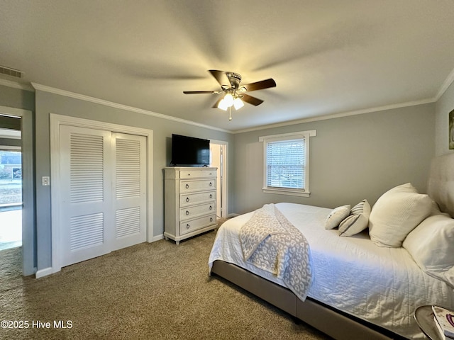 carpeted bedroom with ornamental molding, a closet, and ceiling fan