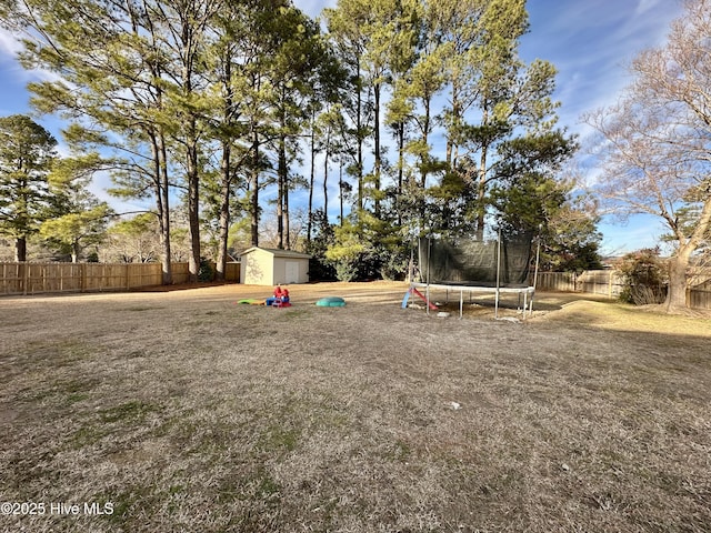 view of yard with a trampoline and a storage shed