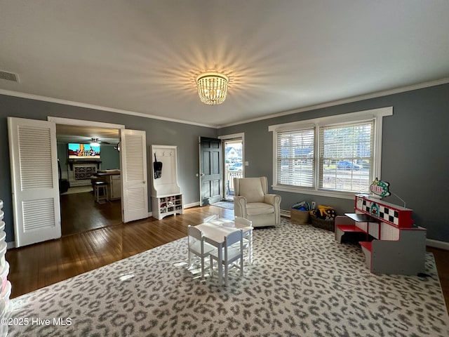 living room with hardwood / wood-style flooring, crown molding, and an inviting chandelier