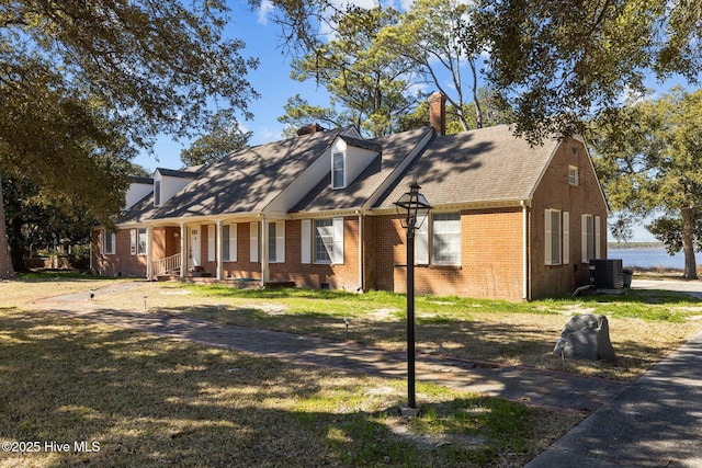 new england style home featuring a front yard and central AC unit