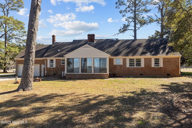 rear view of house featuring a yard and a garage