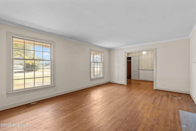 spare room featuring light hardwood / wood-style floors and crown molding