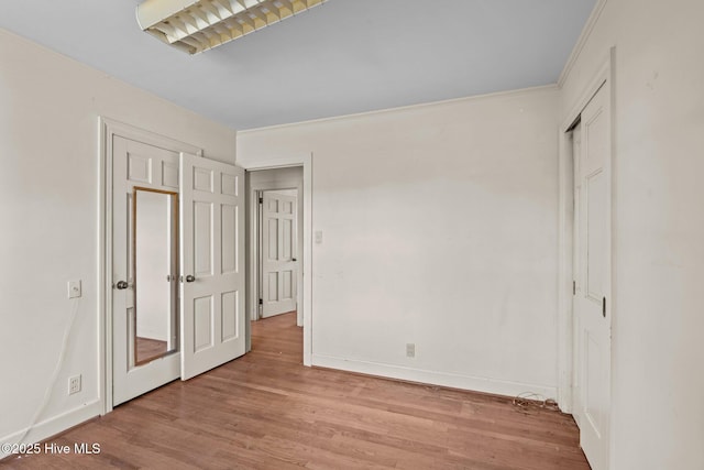 unfurnished bedroom featuring light wood-type flooring and crown molding