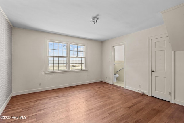 unfurnished bedroom featuring light hardwood / wood-style flooring and ensuite bath