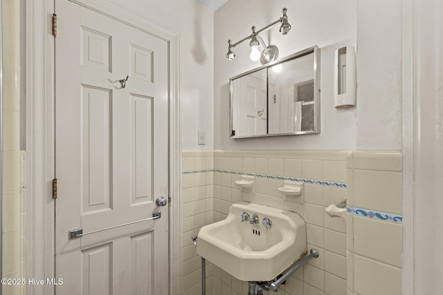 bathroom with sink and tile walls