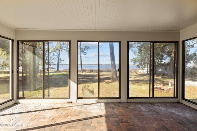 unfurnished sunroom with a water view