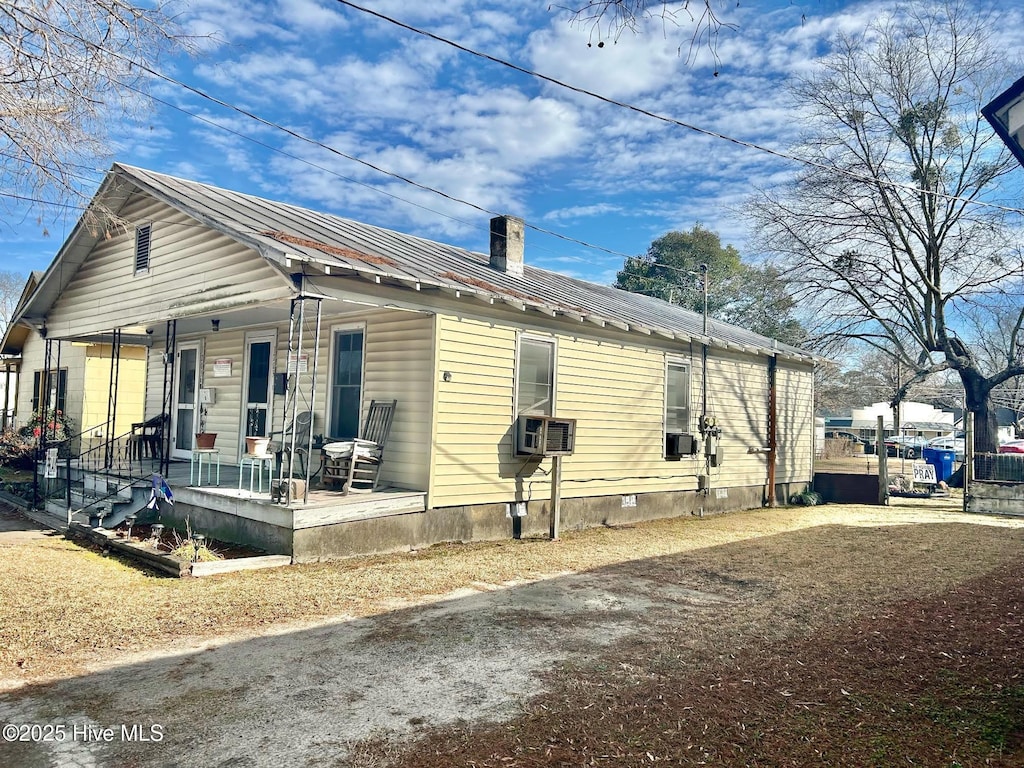 view of front facade with cooling unit and a porch