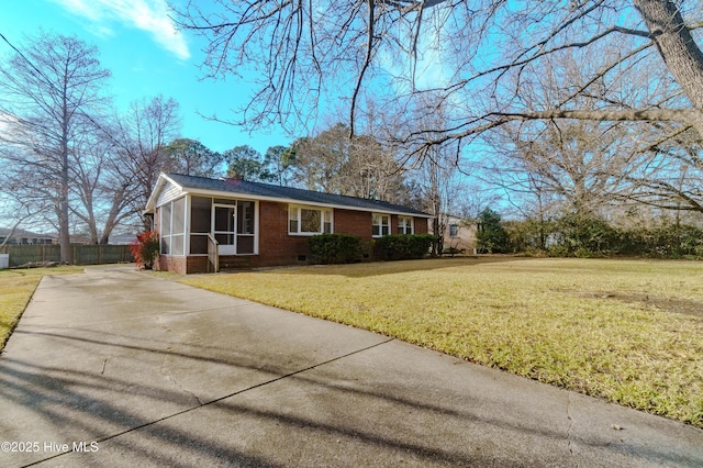 view of front of property featuring a front yard and a sunroom