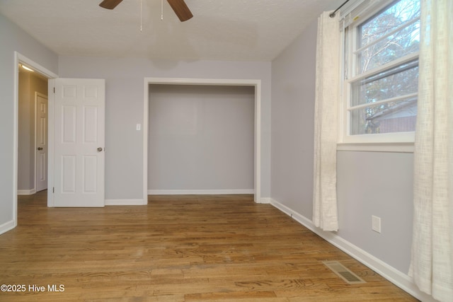 unfurnished bedroom featuring light hardwood / wood-style flooring, a closet, and ceiling fan