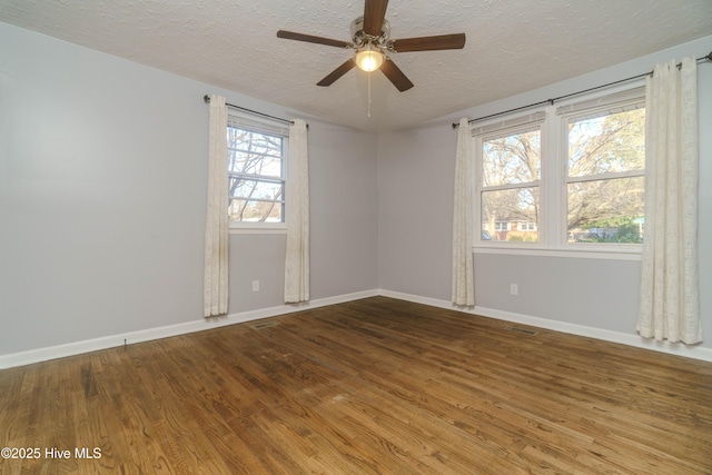 spare room featuring ceiling fan, wood-type flooring, and a textured ceiling