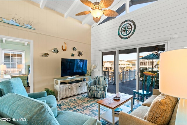 living room featuring a ceiling fan, beam ceiling, and high vaulted ceiling