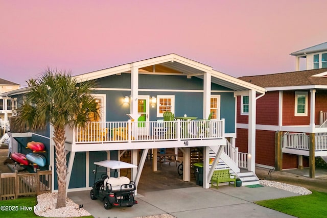 view of front facade with stairway, a porch, a carport, and concrete driveway