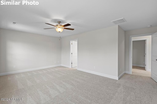 carpeted spare room featuring ceiling fan