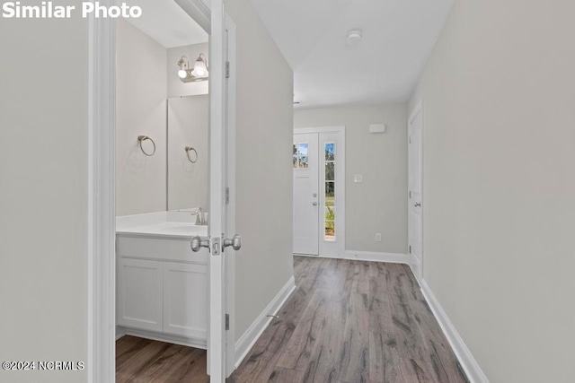 corridor with sink and light hardwood / wood-style flooring