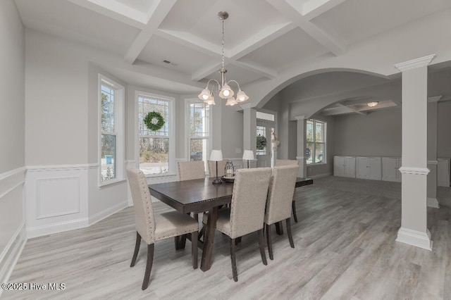 dining space featuring coffered ceiling, beam ceiling, light hardwood / wood-style flooring, and decorative columns