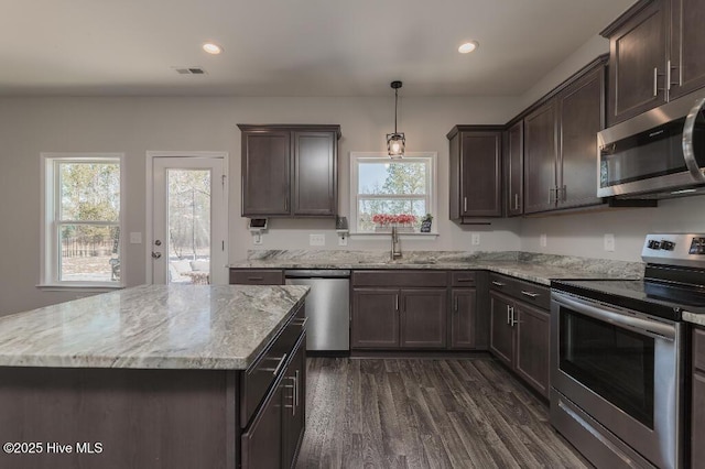 kitchen with a kitchen island, appliances with stainless steel finishes, sink, and decorative light fixtures