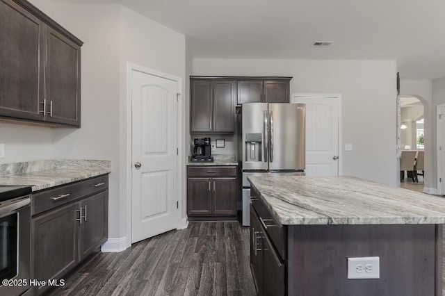 kitchen featuring dark brown cabinets, a center island, and appliances with stainless steel finishes