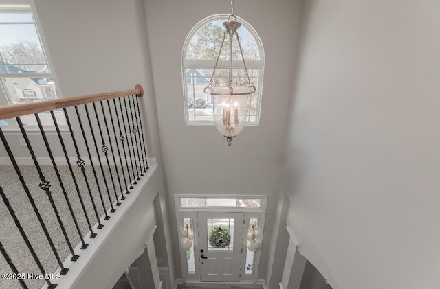 entryway with a towering ceiling and a chandelier