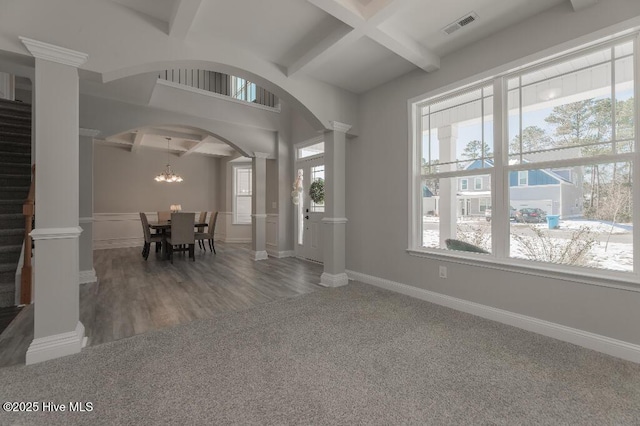 interior space featuring decorative columns, coffered ceiling, carpet floors, and beamed ceiling