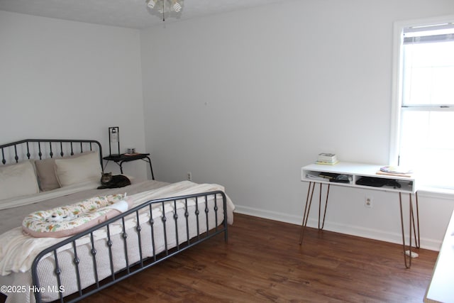 bedroom featuring multiple windows and dark wood-type flooring